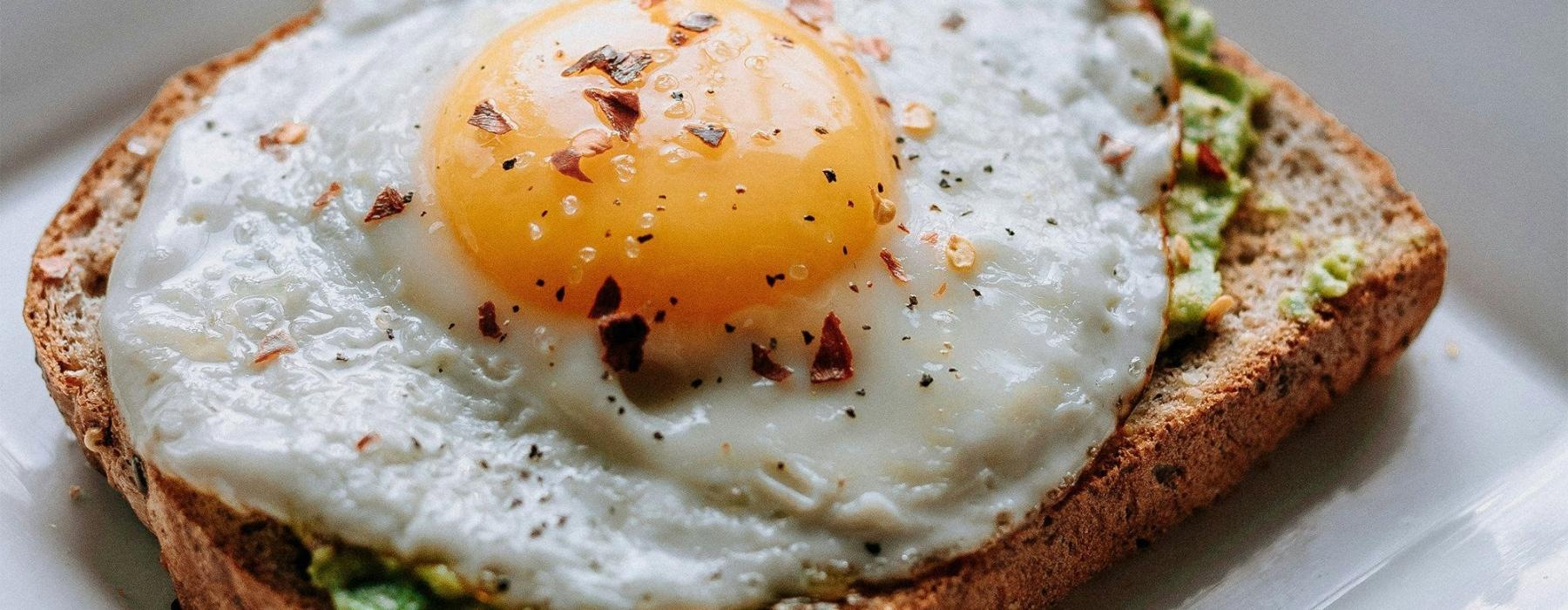 a breakfast sandwich with an egg on top