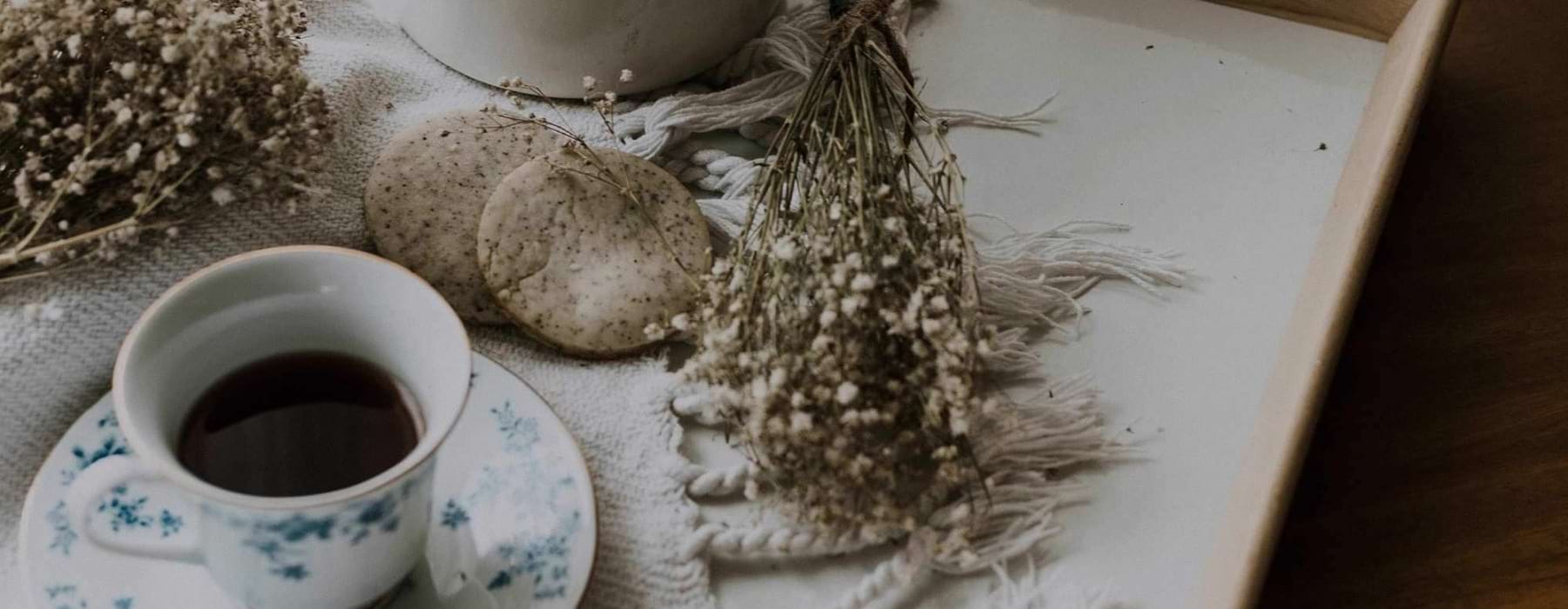 tea and cookies on a serving tray with baby's breath